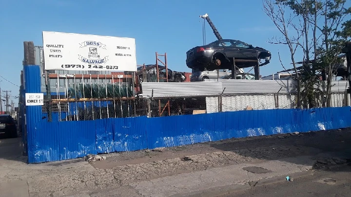 Sign and vehicles at Boss Salvage auto parts.