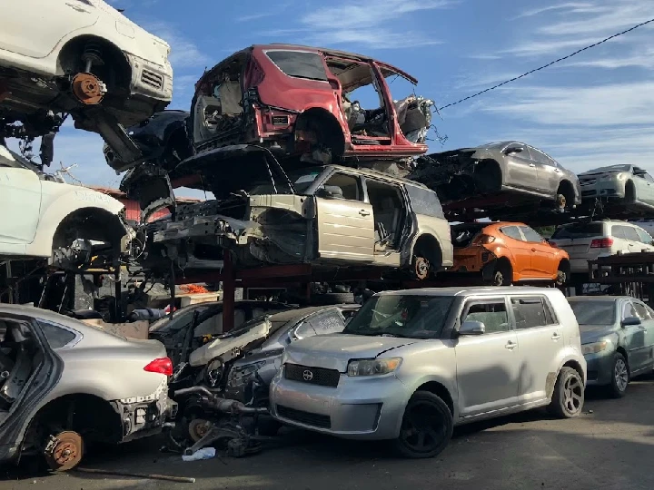 Stacked cars in a salvage yard for used auto parts.