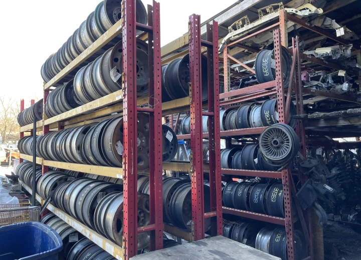 Stacked metal rims displayed on shelves.