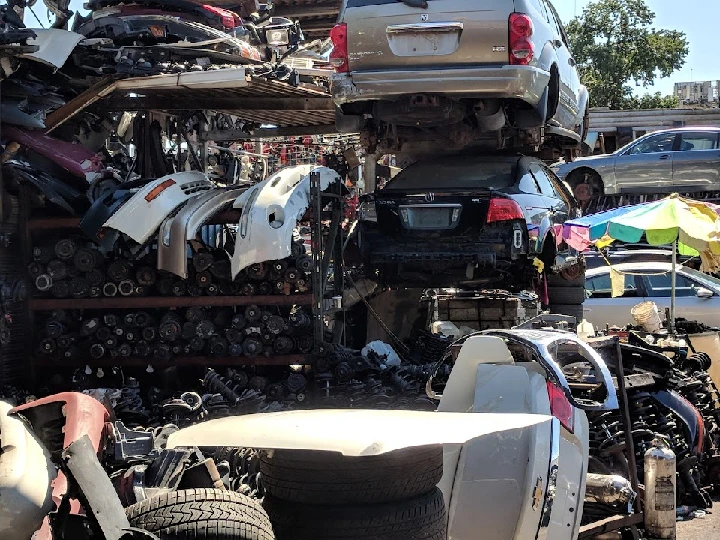 Stacked vehicles and auto parts in a salvage yard.