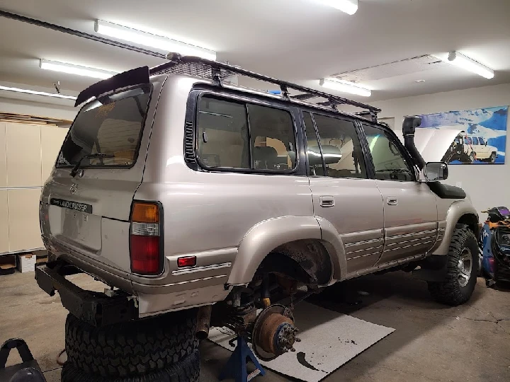 SUV in a shop with parts disassembled.