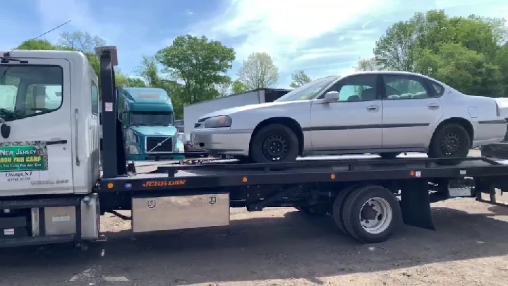 Tow truck loading a junk car for cash offer.