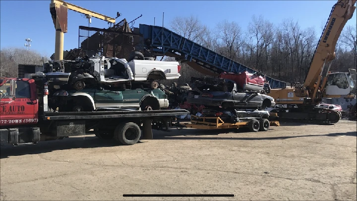 Trucks loaded with salvaged cars at an auto salvage yard.