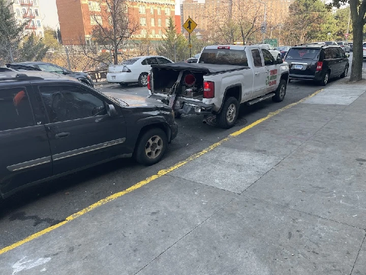 Two parked vehicles, one with rear damage.