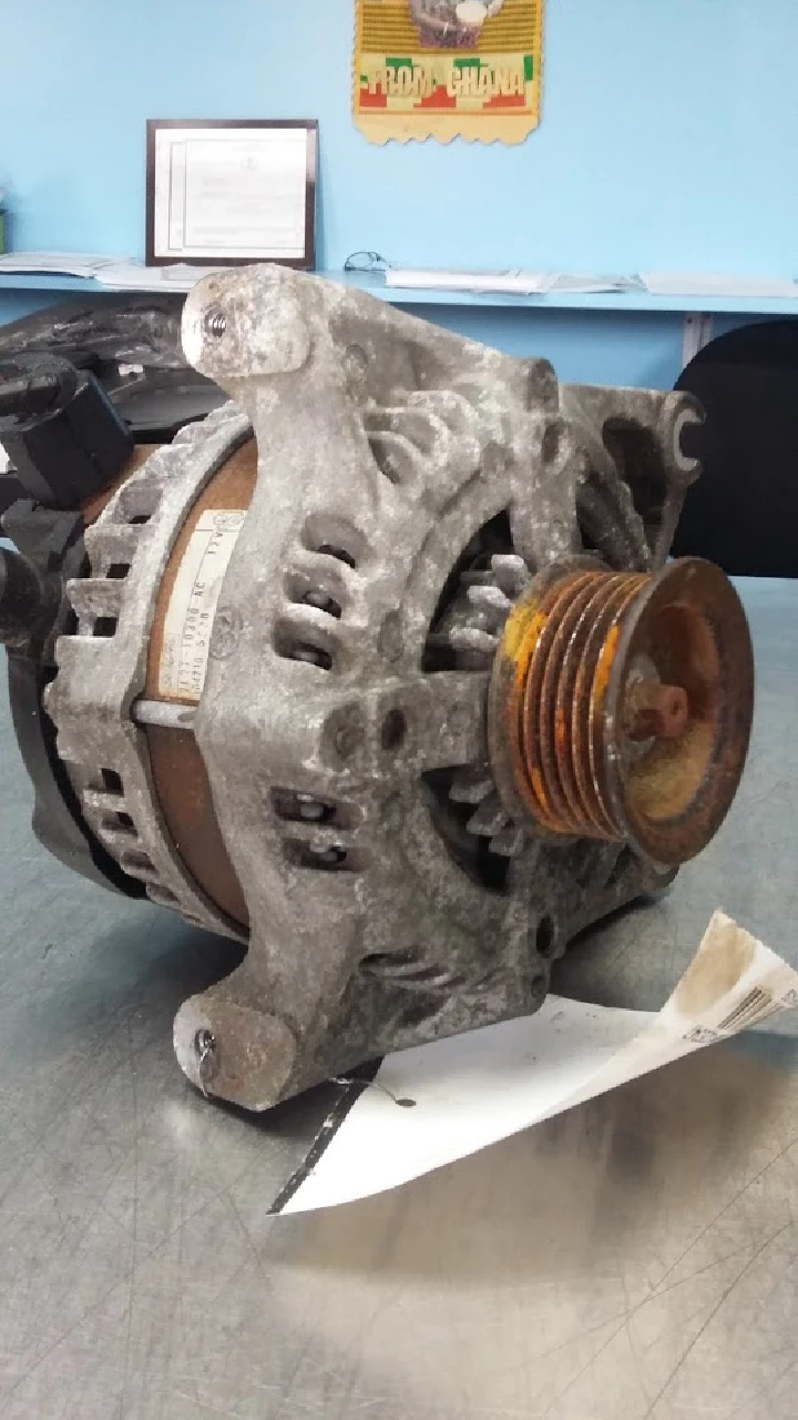 Used auto alternator on a workbench.