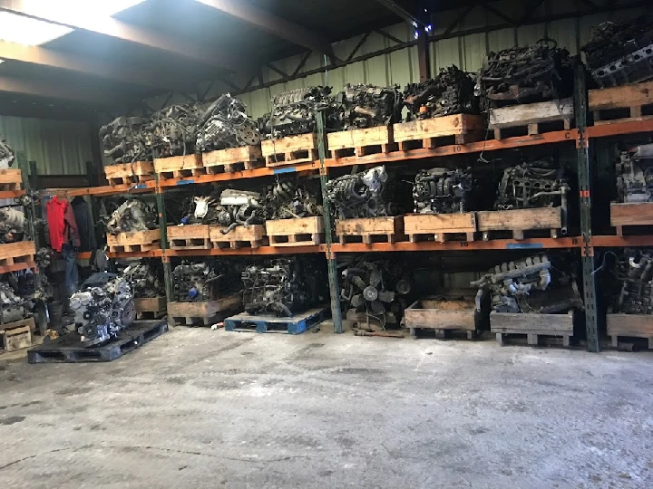 Warehouse filled with stacked automotive engines.