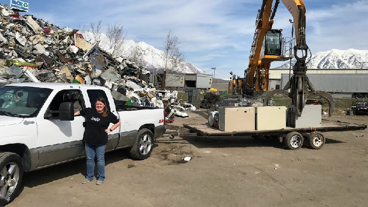 Woman by a truck at a recycling facility.