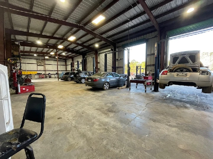 Workshop with cars on lifts and tools visible.