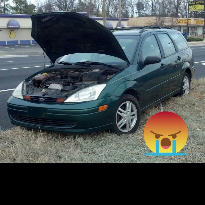 Abandoned green car with hood raised.