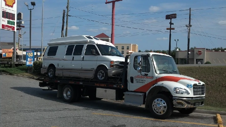 Ackerman Wrecker Service truck towing a van.