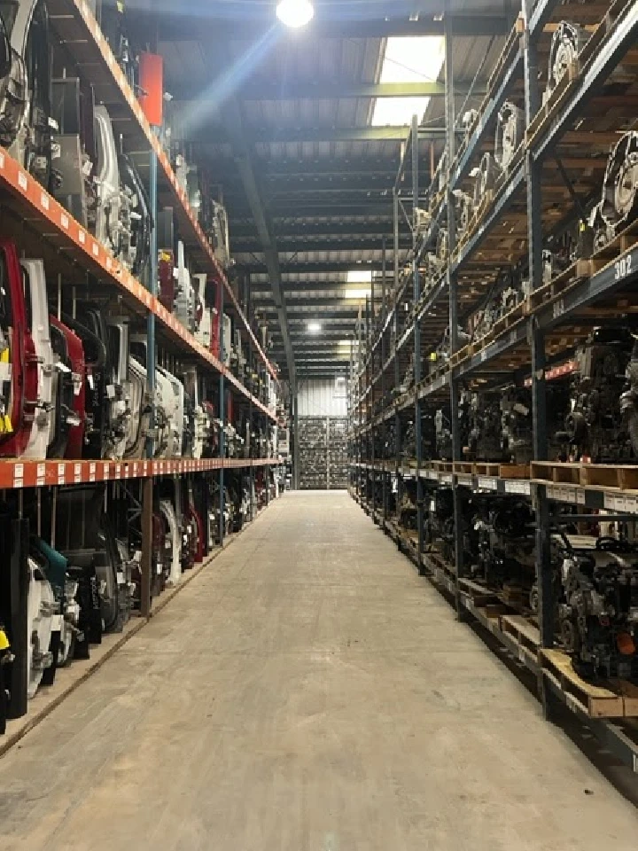 Auto parts and engines stored in an expansive warehouse.