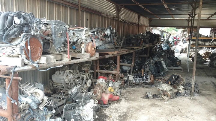 Auto parts storage with various engines stacked.