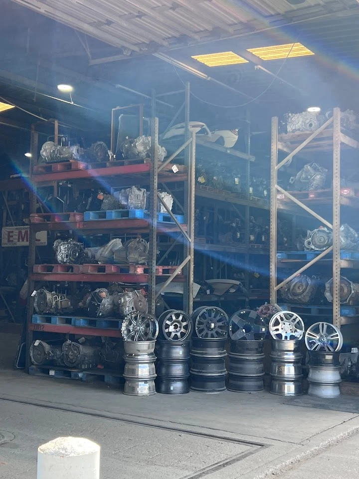 Auto parts warehouse with engines and wheels displayed.