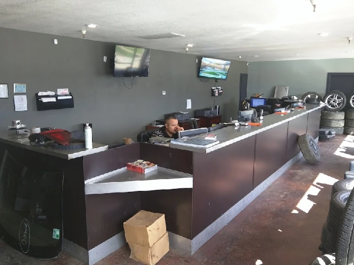 Auto recycling office with staff and tires visible.