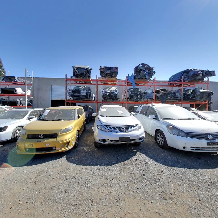 Auto recycling yard with various salvaged vehicles.