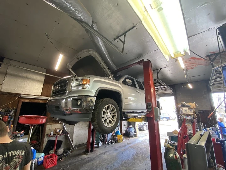 Auto repair shop with a lifted truck for maintenance.