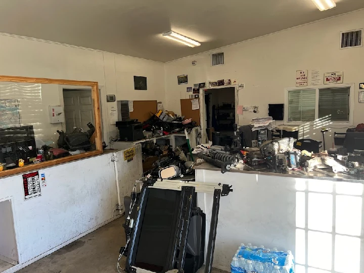 Auto salvage shop interior with various parts scattered.