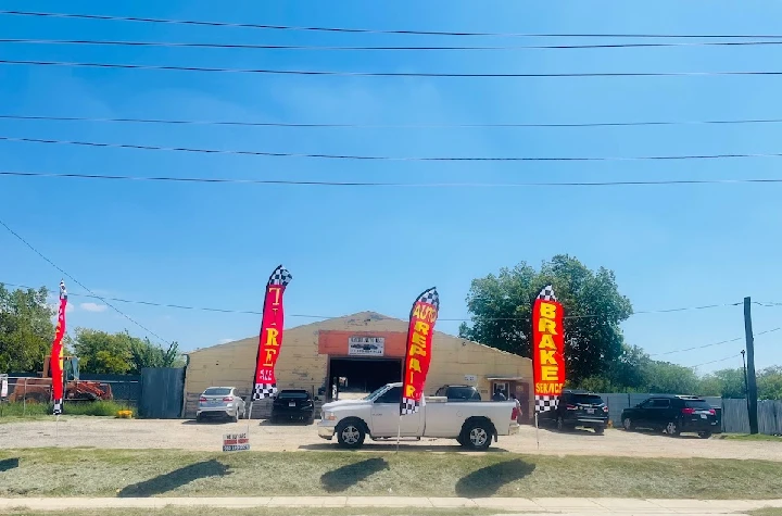 Auto salvage yard with colorful service banners.