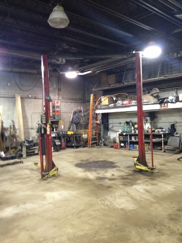 Auto shop with lifts and tools in a spacious garage.