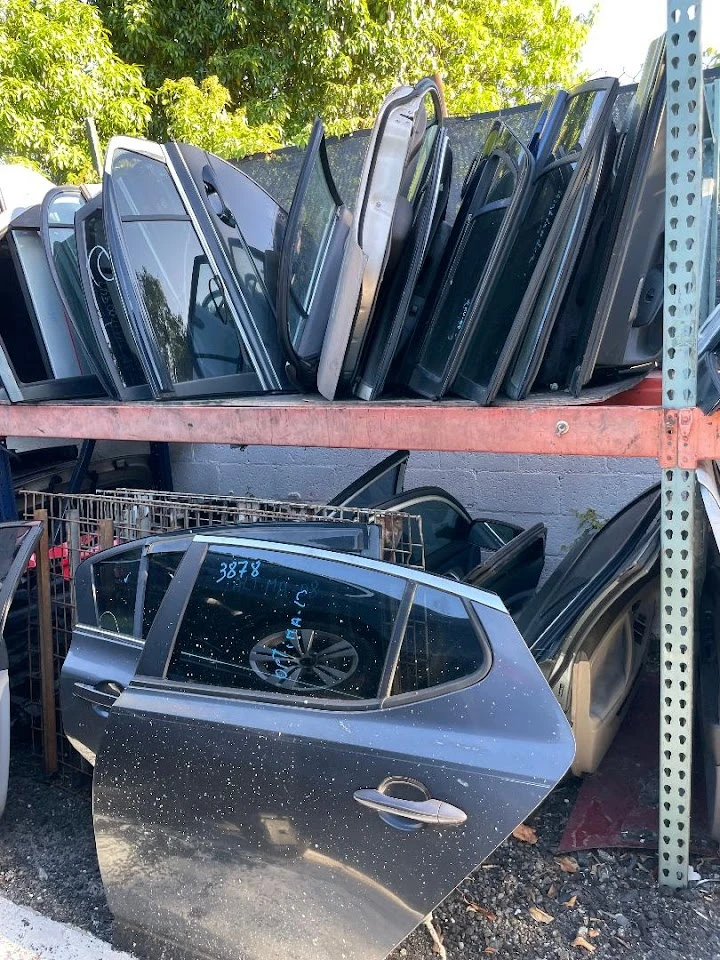 Automotive parts stacked in a salvage yard.