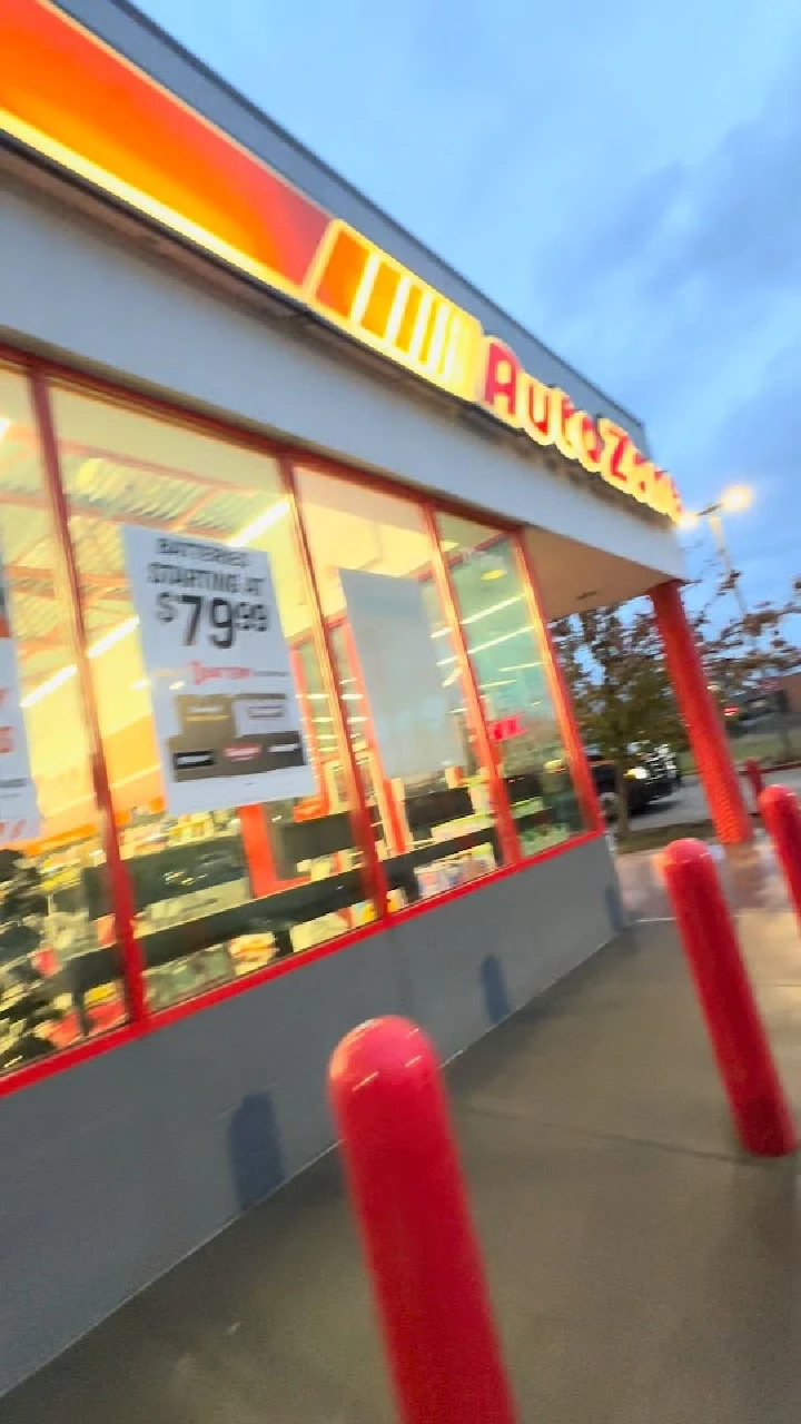 AutoZone store front with red poles and signs.