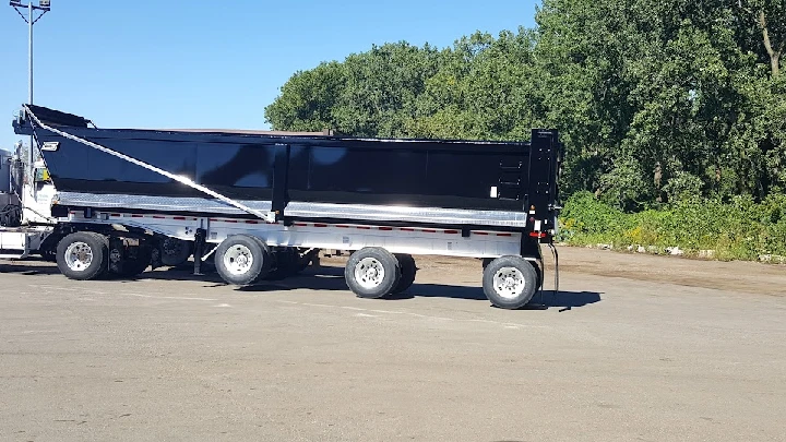 Black recycling truck parked in a lot.