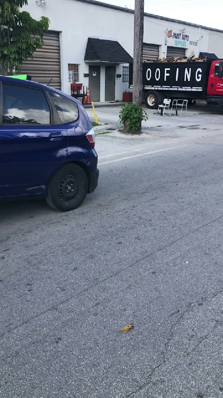 Blue car parked outside an auto supply store.