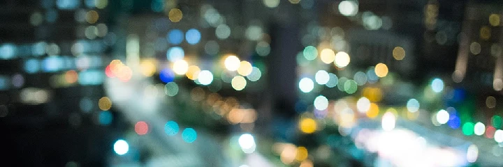 Blurry city lights at night, colorful bokeh effect.