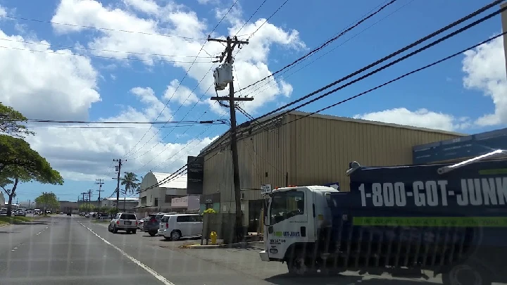 C M Recycling LLC facility with blue sky and vehicles.