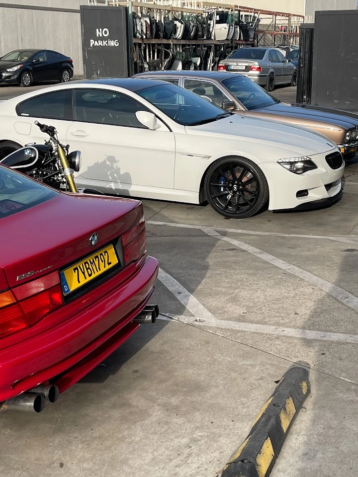 Cars parked at QBM AUTO with No Parking sign.