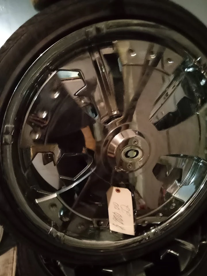 Chrome alloy wheel on display with price tag.