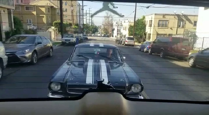 Classic Mustang on the street with other cars.