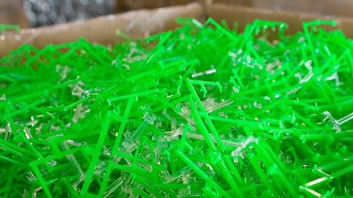 Colorful green plastic scraps ready for recycling.