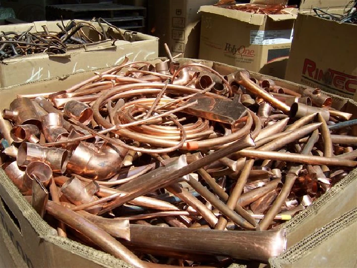 Copper scraps piled in cardboard boxes.