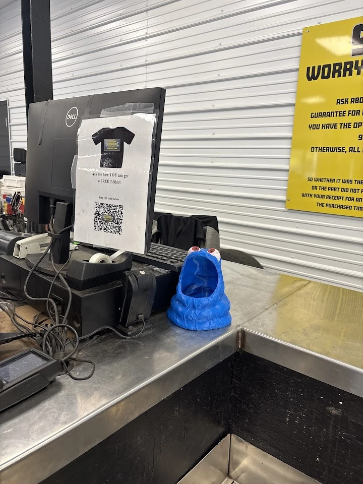 Counter display with a blue figurine and sign.