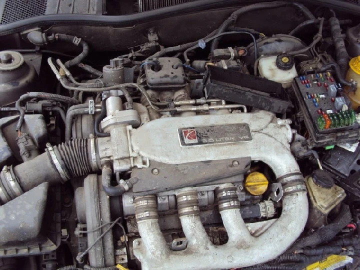 Engine components in a vehicle, dirty and worn.