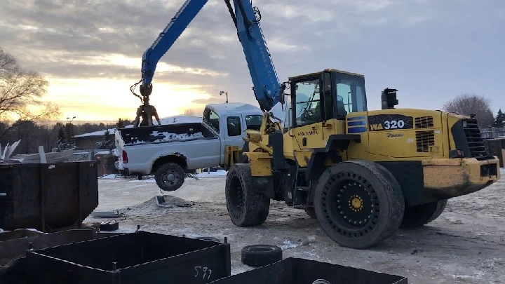 Excavator lifts a truck at EMR Northern Metals yard.