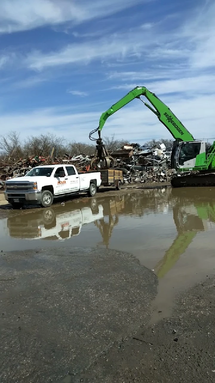 Excavator and truck at a recycling yard.