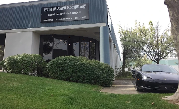 Exotic Auto Recycling building with a black car outside.