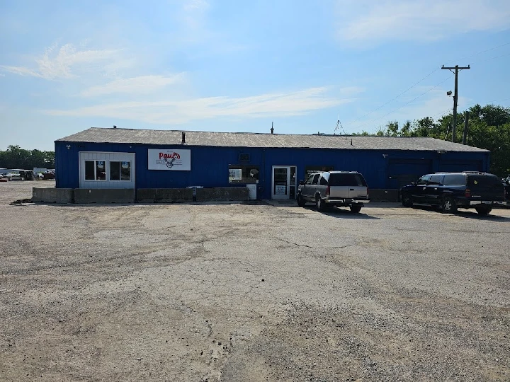 Exterior of Paul's Auto Yard building with parked cars.