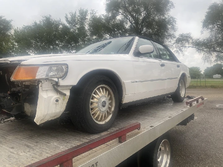 Junk car on a tow truck awaiting removal.