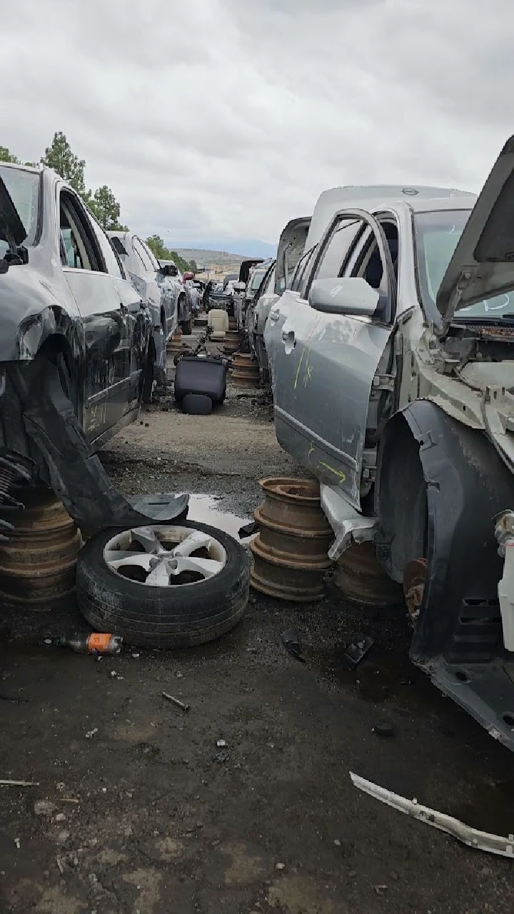 Junkyard with abandoned cars and scattered tires.