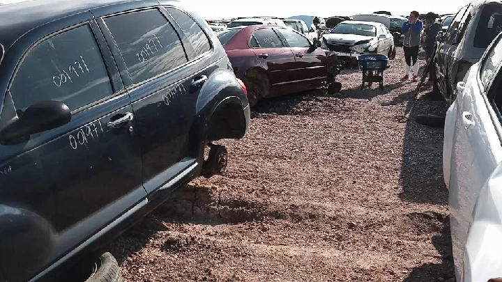 Junkyard filled with abandoned vehicles and parts.