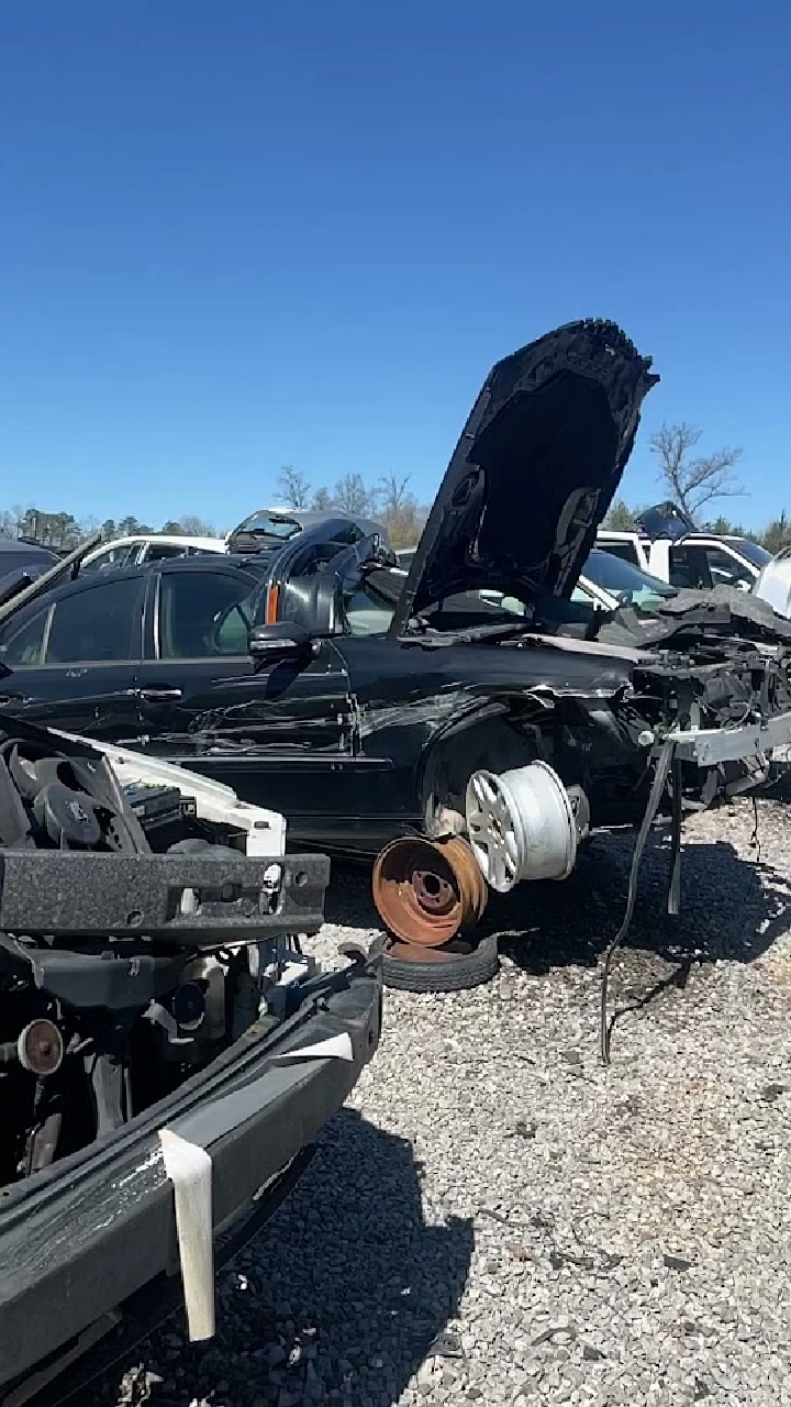 Junkyard scene with discarded cars and parts.