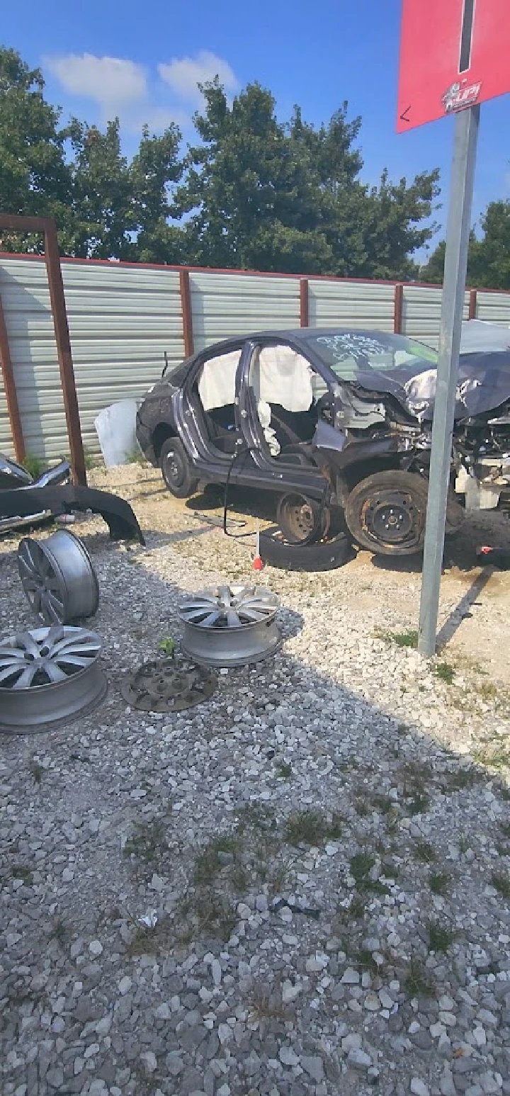 Junkyard scene with dismantled vehicles and wheels.