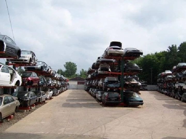 Junkyard with stacked cars for auto parts.