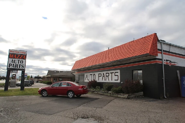 Mazza Auto Parts storefront with a red car outside.