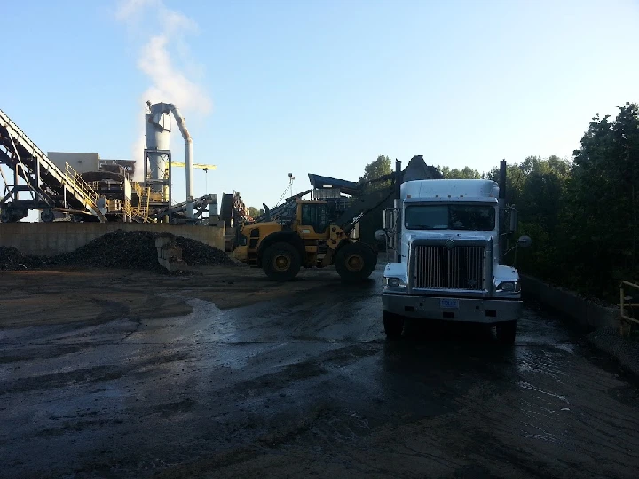 Metal recycling facility with trucks and machinery.