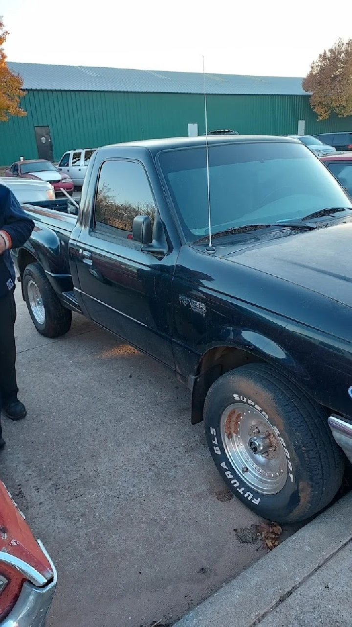 Old black pickup truck with flat tires.