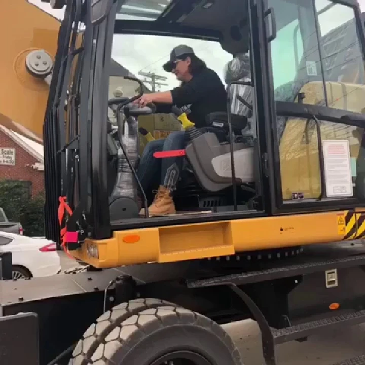 Operator in heavy machinery at metal recycling site.